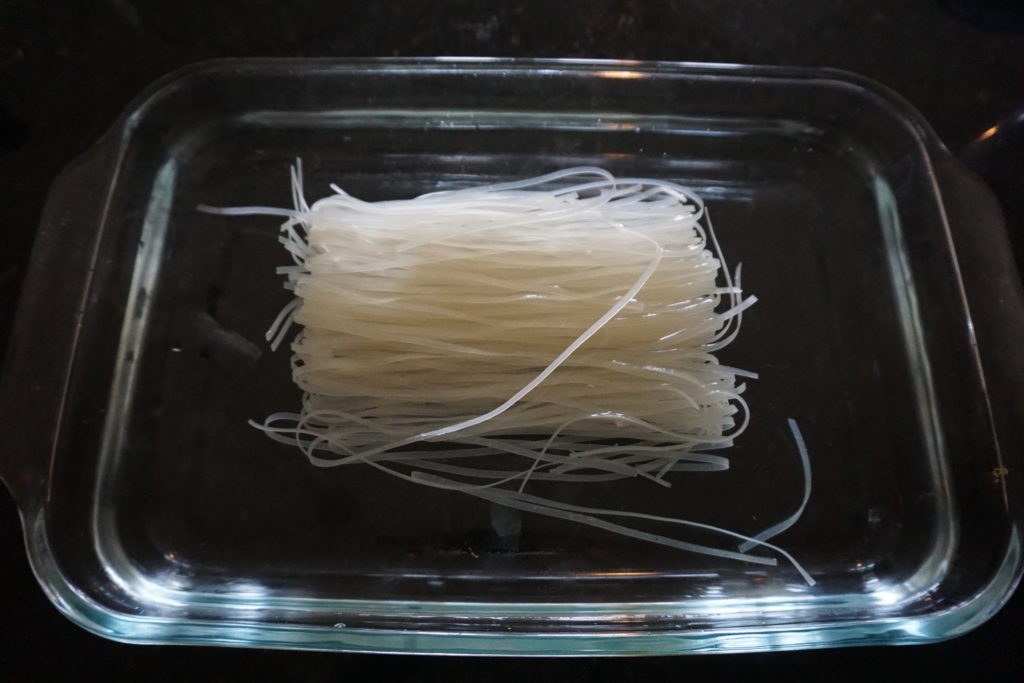 Rice noodles being soaked in water.