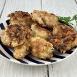 Coconut Shrimp on a blue and white plate with a sprig of parsley