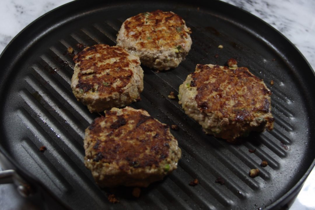 FODMAP safe turkey burgers cooking on the grill pan.