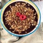 FODMAP safe breakfast - Acai bowl topped with FODMAP safe granola and raspberries