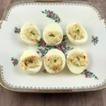 6 deviled eggs on a vintage plate