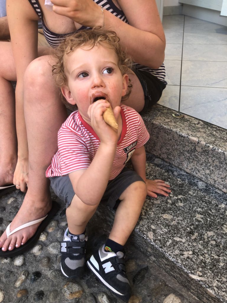 Sweet toddler eating gelato and having it all over his gelato!