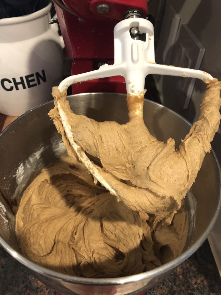 Cookie dough batter being mixed together in an electric mixer.