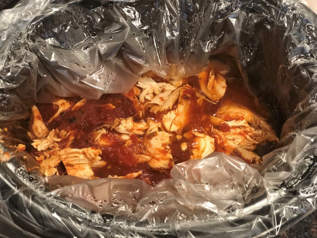 Chicken breasts shredded in FODMAP safe salsa in a crockpot.