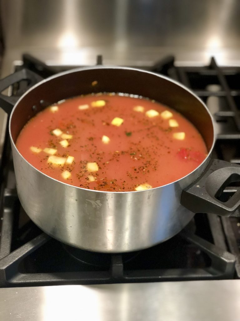 A pot of minestrone soup simmering on the stove top. 